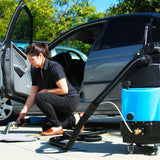 Detailer using the Mytee 8070 heated carpet extractor to clean vehicle interior carpet mats
