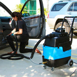 Mytee 8070 heated upholstery extractor being used to clean carpet and seats inside a vehicle